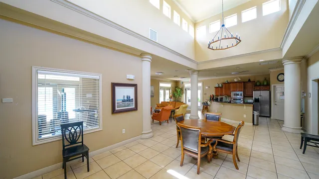 a living room with furniture a large window and stainless steel appliances