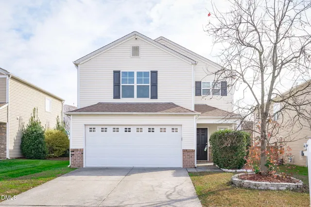 a view of a house with a yard and garage