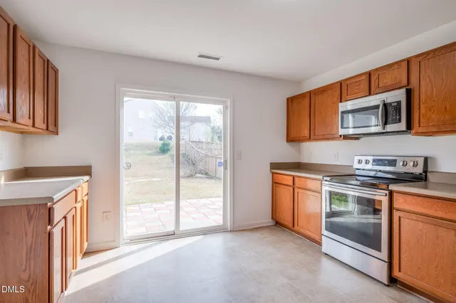 an empty room with wooden floor and window