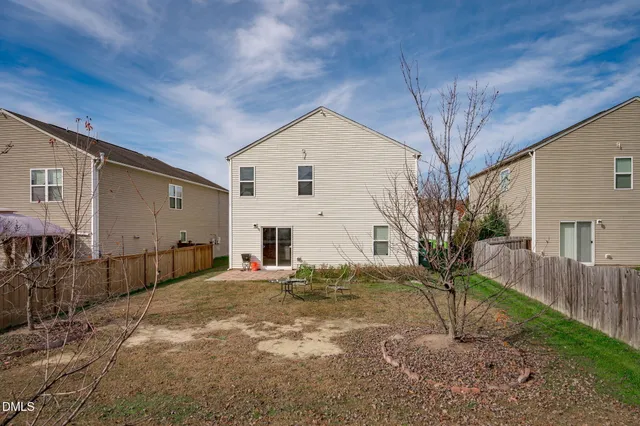 a view of large yard with wooden fence