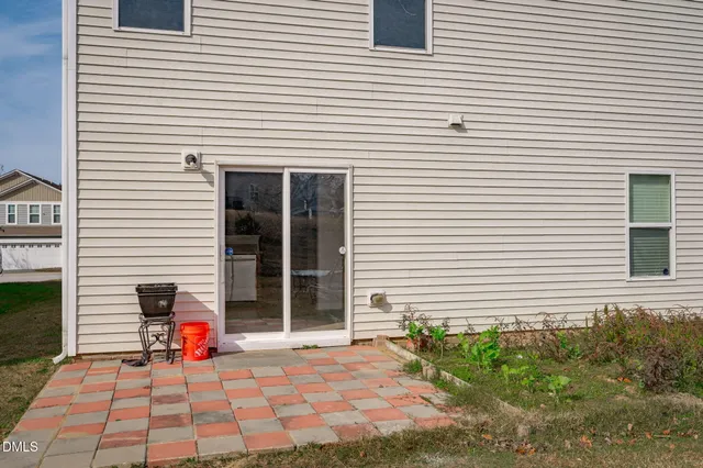 an empty room with wooden floor chandelier and windows
