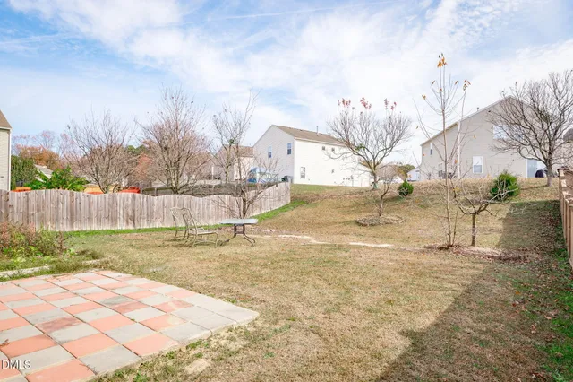 an empty room with wooden floor ceiling fan and window