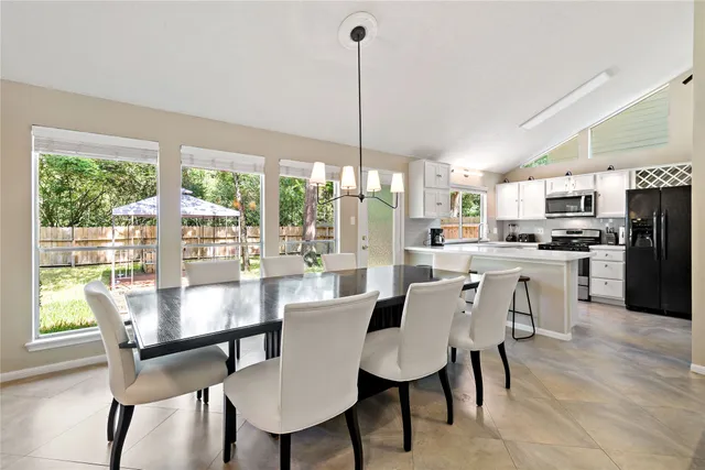 a dining room with furniture a chandelier and a floor to ceiling window