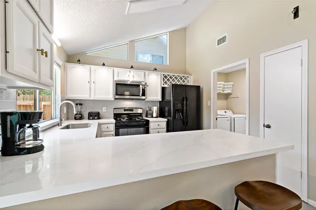 a kitchen with stainless steel appliances kitchen island granite countertop a refrigerator a stove a sink dishwasher with a dining table and chairs