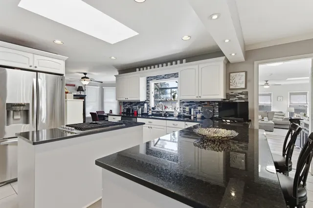 a kitchen with stainless steel appliances granite countertop a sink refrigerator and cabinets
