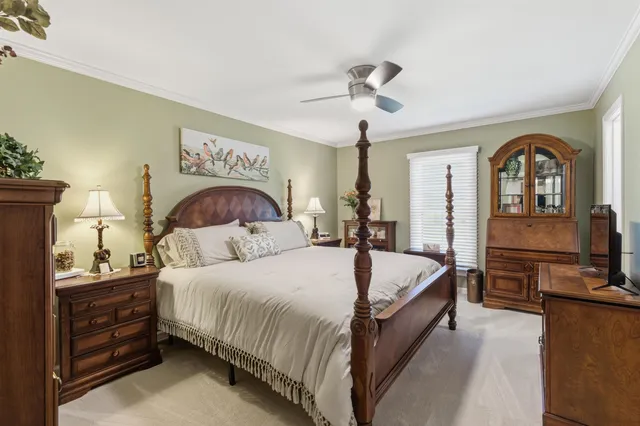 a bedroom with a large bed and a chandelier