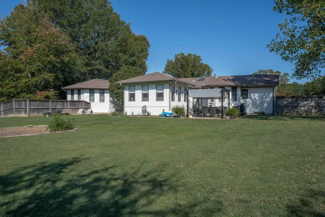 a front view of a house with a garden and trees