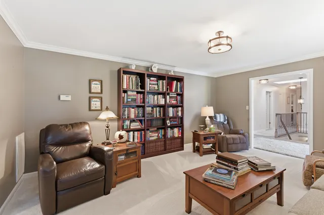 a living room with furniture a bookshelf and a window