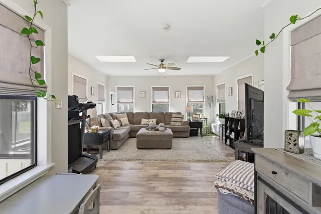 a living room with furniture kitchen view and a window