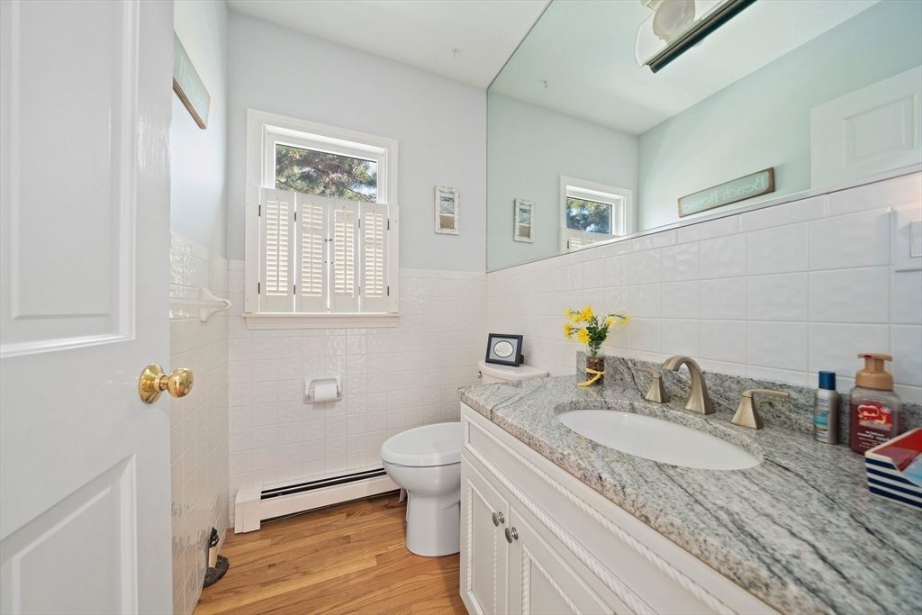 97 Central Avenue Scituate, MA 02050 - Photo 17 of 41 a bathroom with a granite countertop sink a toilet and a mirror