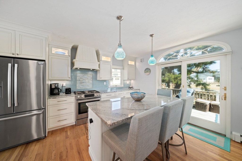 97 Central Avenue Scituate, MA 02050 - Photo 8 of 41 a kitchen with stainless steel appliances granite countertop a stove a refrigerator a kitchen island a dining table and chairs