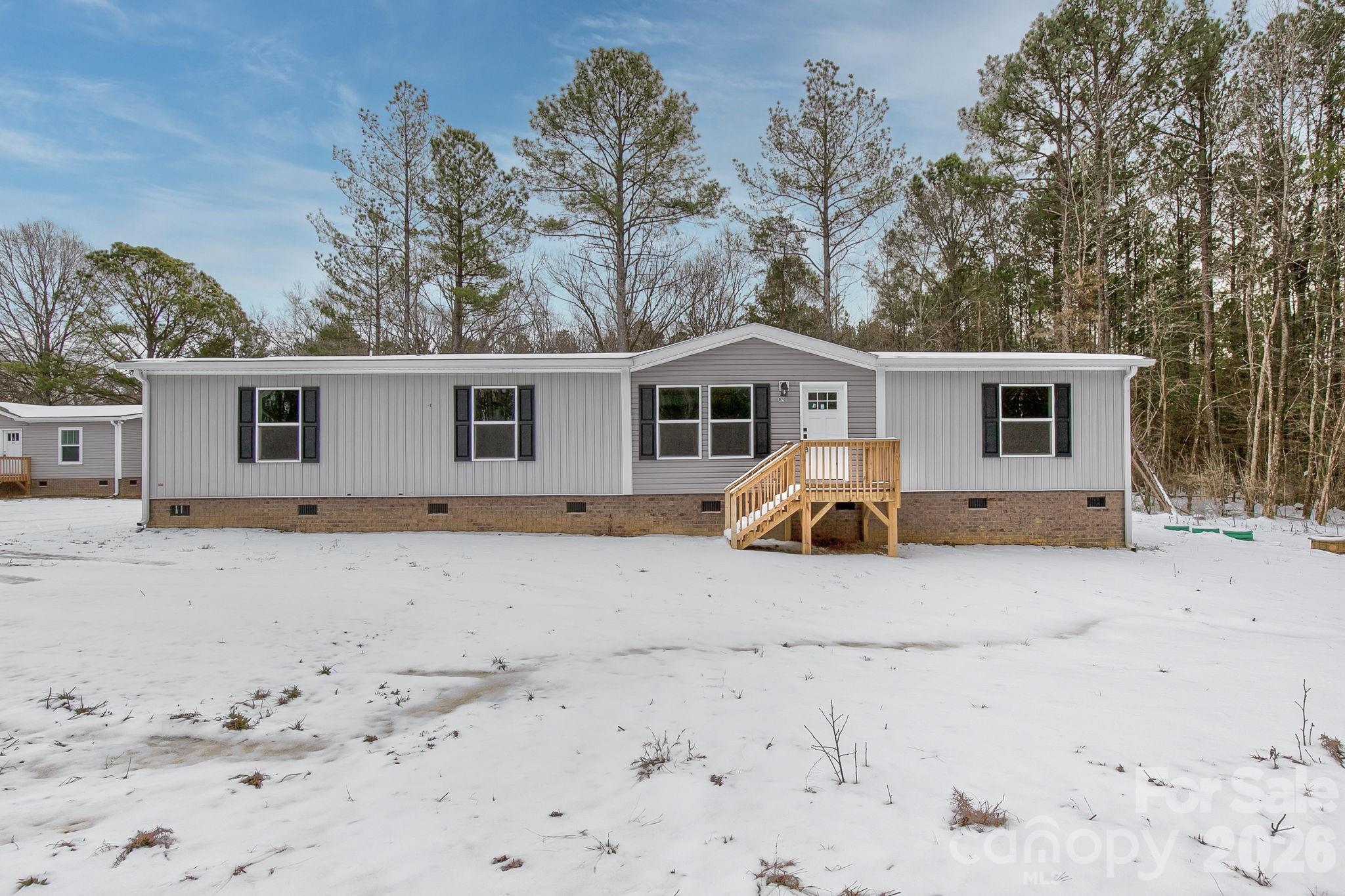 a view of a house with a yard covered with snow in front of house