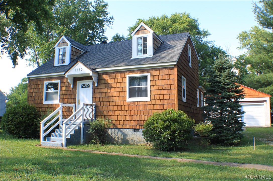 a front view of a house with a yard and green space