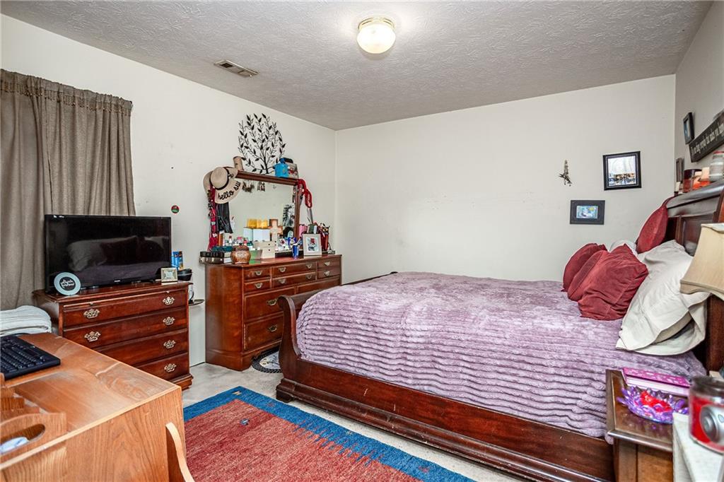 194 Cemetery Road Luthersville, GA 30251 - Photo 16 of 19 a bedroom with a bed and a flat screen tv