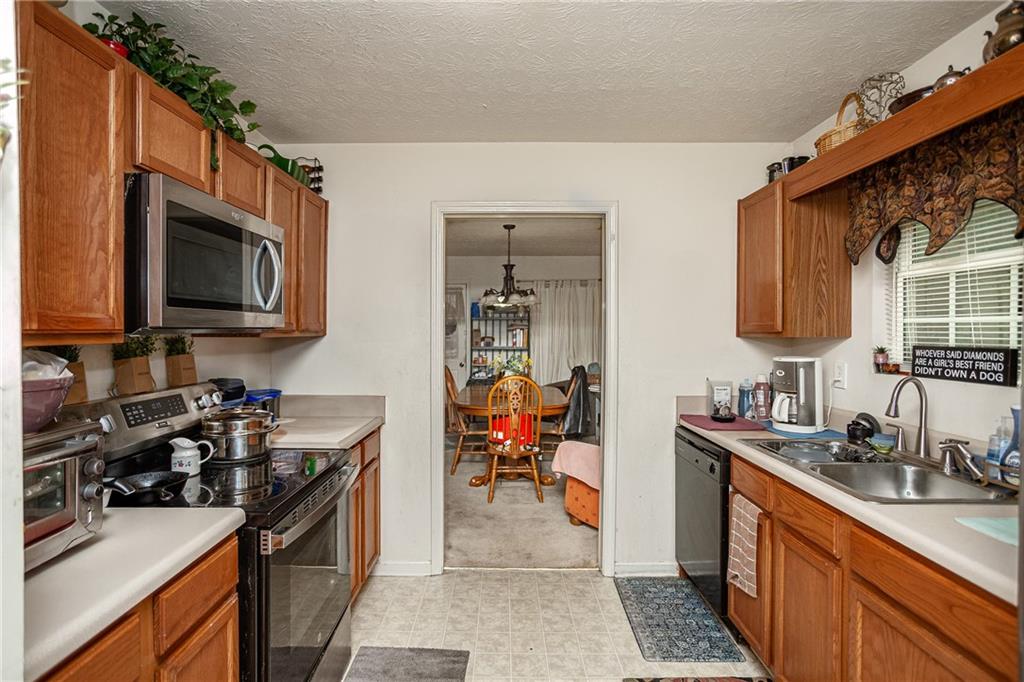 194 Cemetery Road Luthersville, GA 30251 - Photo 10 of 19 a kitchen with stainless steel appliances a stove sink microwave and cabinets