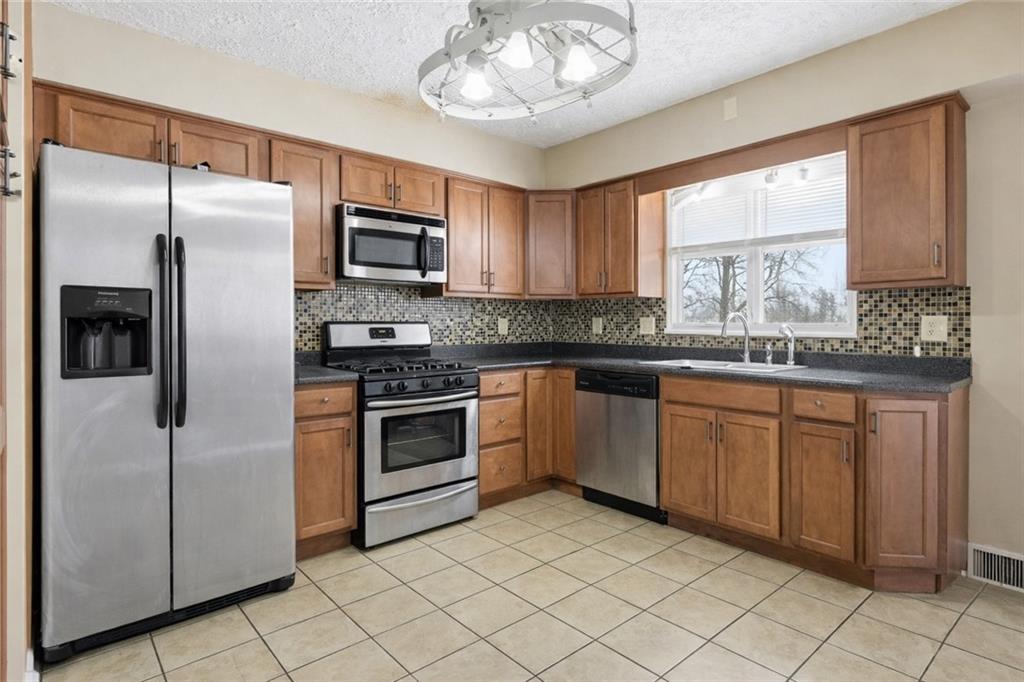 2129 Admiral Street Aliquippa, PA 15001 - Photo 11 of 34 a kitchen with granite countertop stainless steel appliances a sink and a window