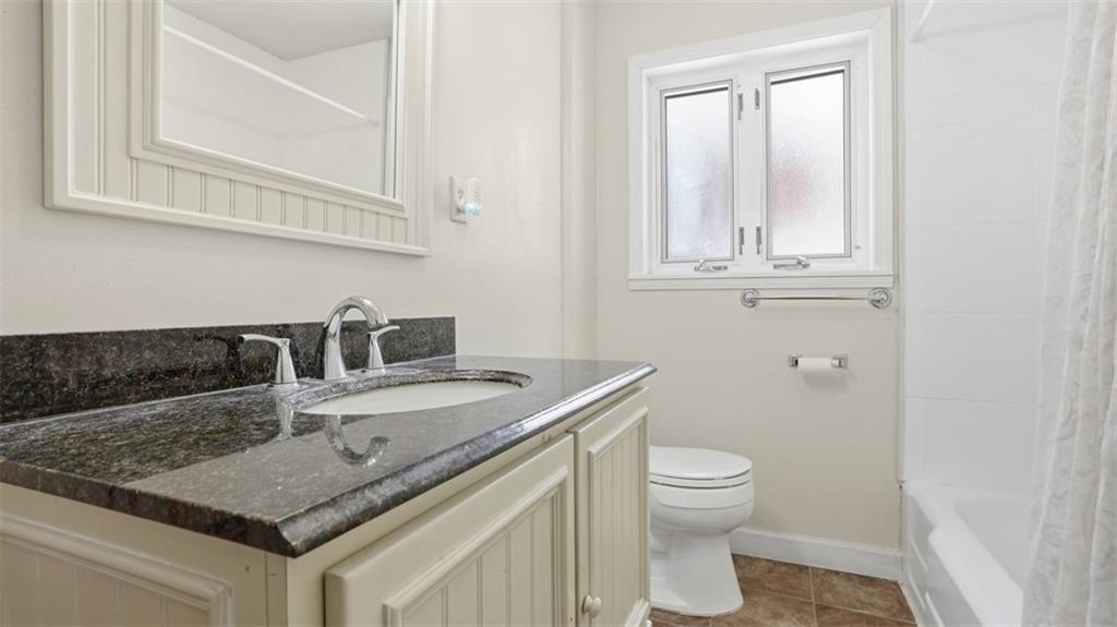 2129 Admiral Street Aliquippa, PA 15001 - Photo 18 of 34 a bathroom with a granite countertop sink a toilet and a mirror