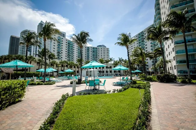 a view of a garden with a table and chairs under an umbrella