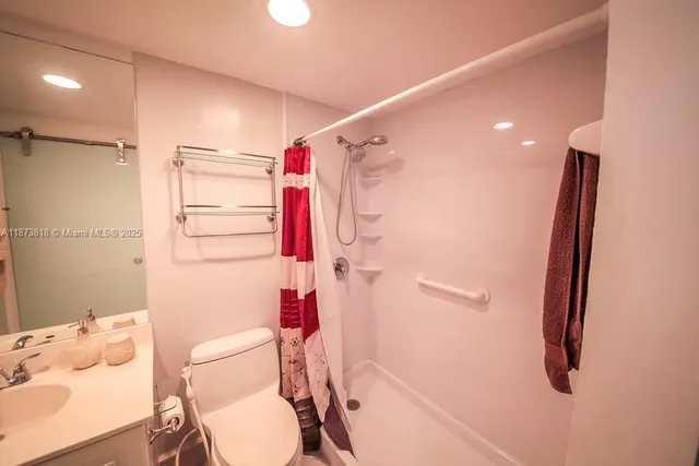 a bathroom with a sink vanity mirror and shower
