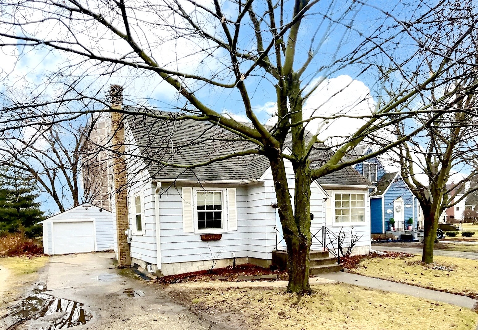 a white house that has a tree in front of it