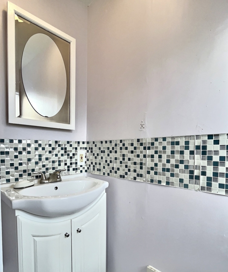 712 South 4th Street DeKalb, IL 60115 - Photo 16 of 25 a bathroom with a sink and a mirror