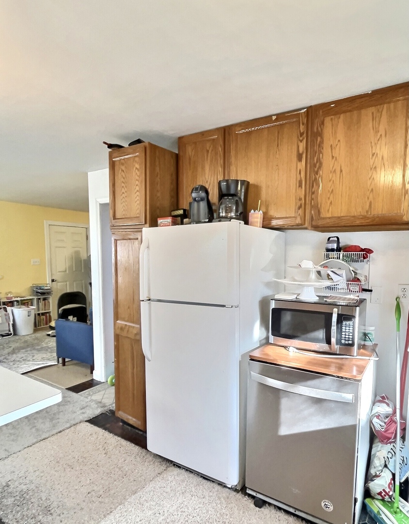 712 South 4th Street DeKalb, IL 60115 - Photo 5 of 25 a kitchen with a refrigerator a stove top oven a sink and cabinets