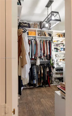 a view of walk in closet with clothes and shoes