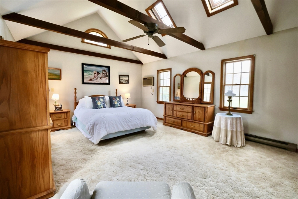 93 Ferry Road Salisbury, MA 01952 - Photo 15 of 32 a spacious bedroom with a bed mirror and a window
