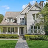 a front view of a house with a yard and potted plants
