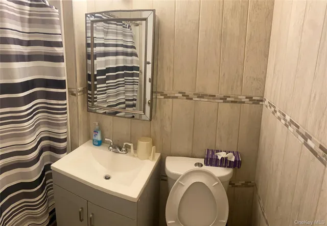 a bathroom with a sink a toilet and a mirror