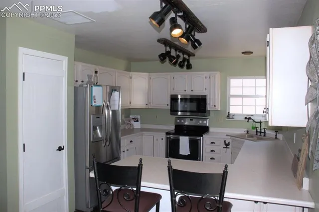 a kitchen with cabinets appliances and a sink