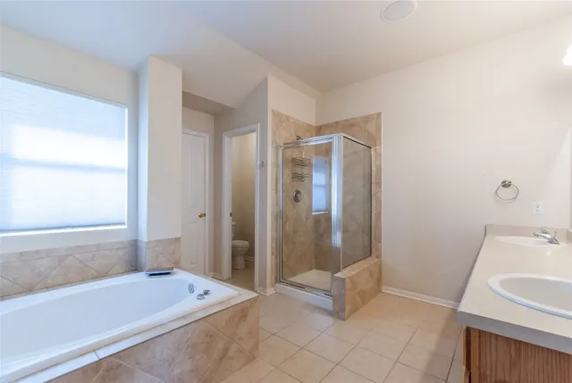 a en suite bathroom with a tub sink and mirror