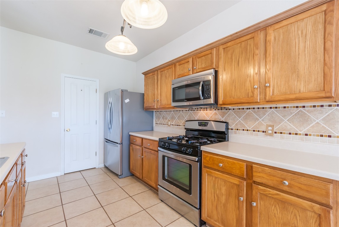 1101 Hidden View Place Round Rock, TX 78665 - Photo 7 of 37 a kitchen with stainless steel appliances granite countertop a stove a sink and a microwave