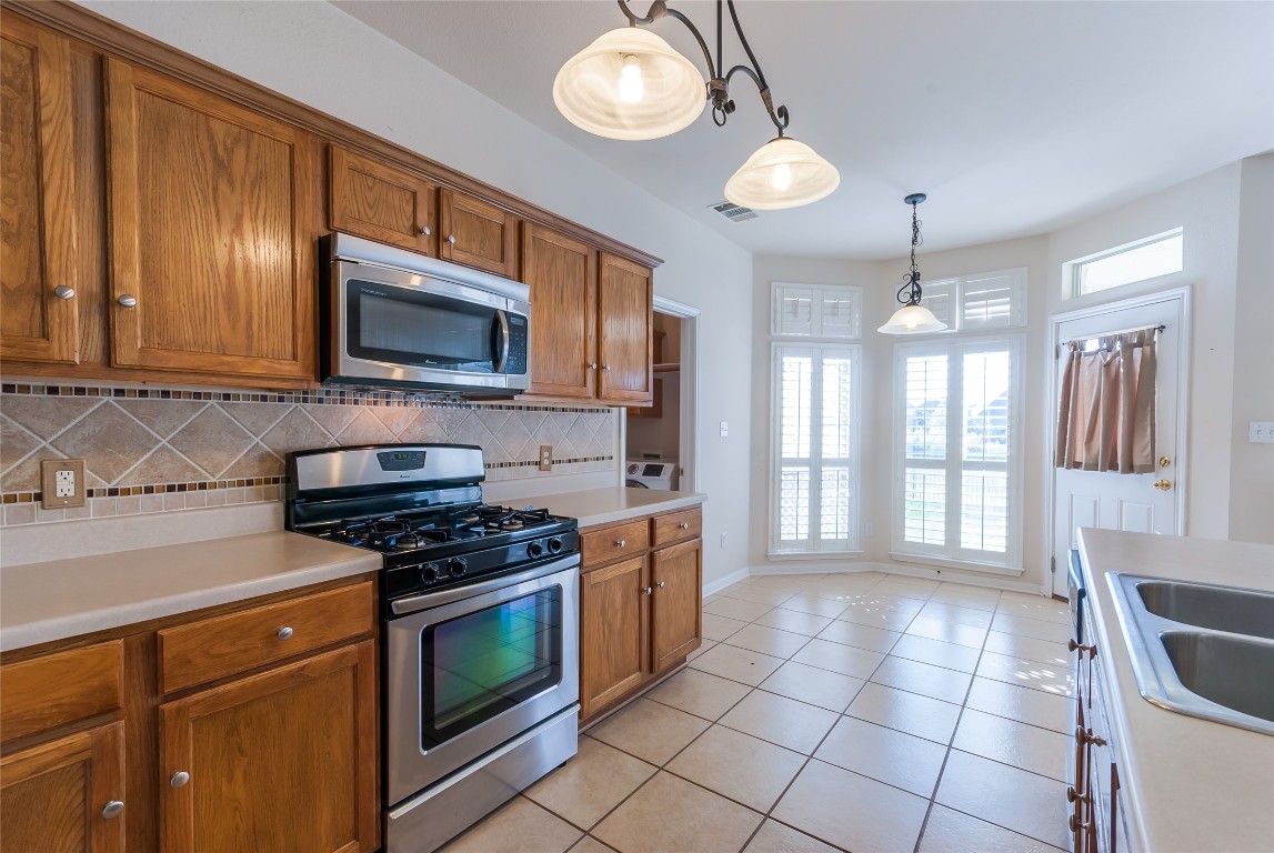 1101 Hidden View Place Round Rock, TX 78665 - Photo 9 of 37 a kitchen with a stove cabinets and microwave