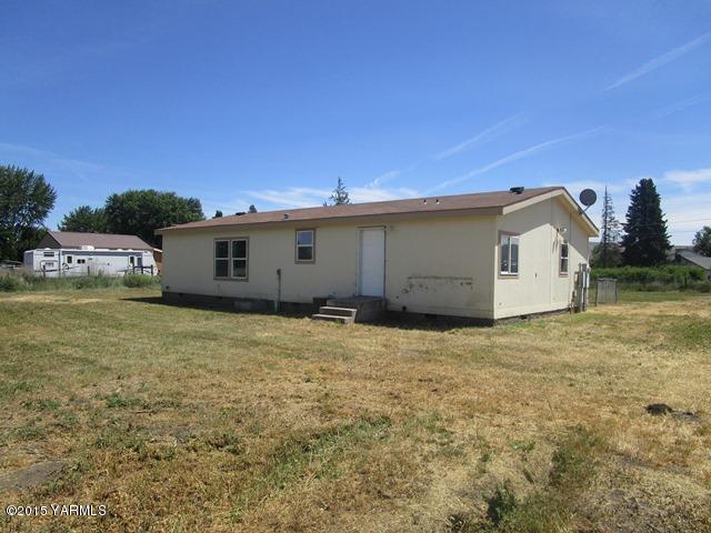 11303 Gilbert Road Yakima, WA 98903 - Photo 22 of 28 a backyard of a house with a yard and garage