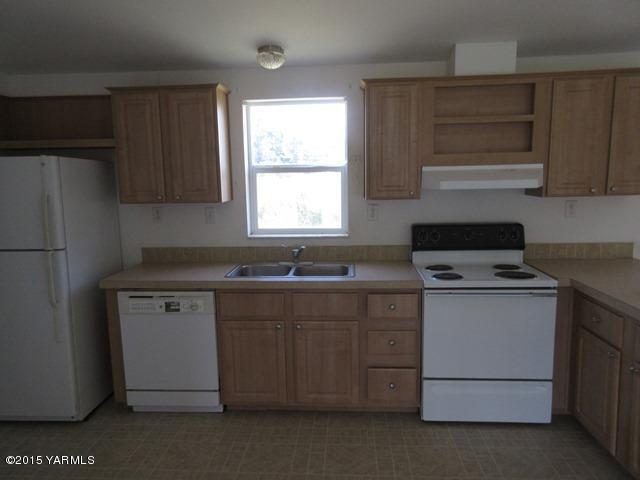 11303 Gilbert Road Yakima, WA 98903 - Photo 7 of 28 a kitchen with a stove and a refrigerator