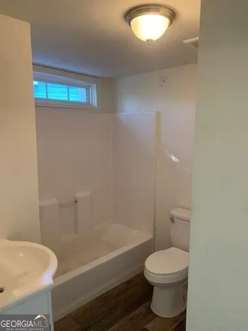 a bathroom with a toilet a sink and bathtub