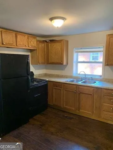 a kitchen with granite countertop a refrigerator and a sink