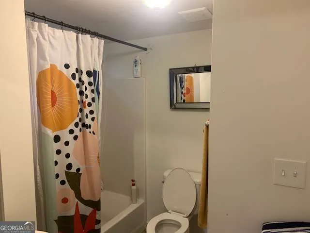 a bathroom with a shower toilet and sink