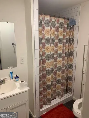 a bathroom with a sink and mirror with toilet