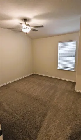 an empty room with a chandelier fan