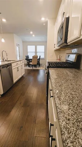 a kitchen with stainless steel appliances granite countertop a sink stove and refrigerator