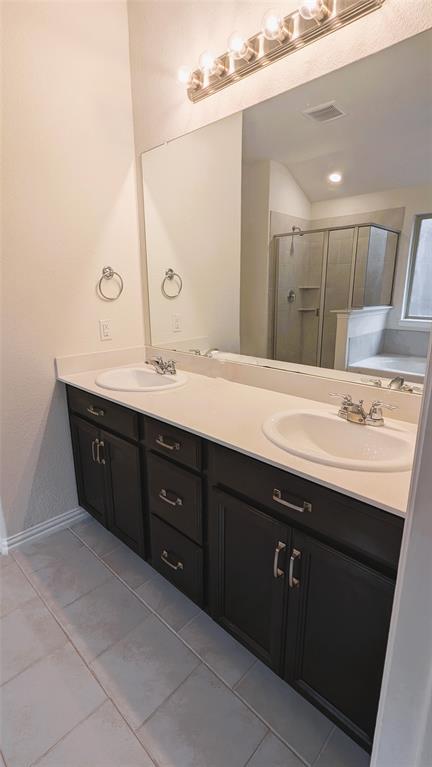 2408 Wildhaven Road Crandall, TX 75114 - Photo 30 of 39 Full bathroom featuring light tile patterned floors, double vanity, a shower stall, and a bath