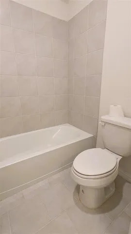 a white toilet and tub sitting next to a bathroom sink