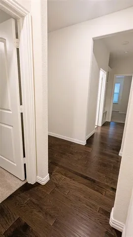 a view of a hallway with wooden floor and stairs