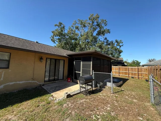 a backyard of a house with table and chairs