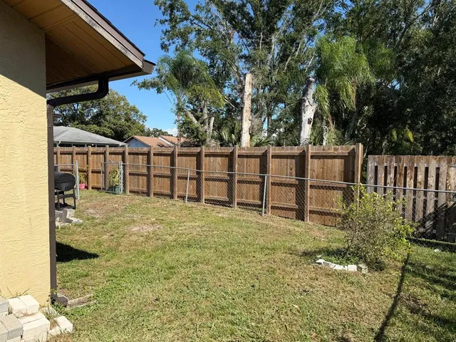 a view of backyard with seating and trees