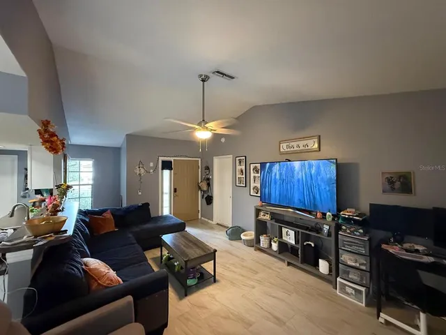 a living room with furniture a ceiling fan and a window
