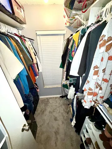 a view of walk in closet with clothes and shoes