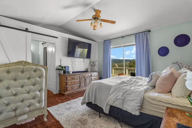 a spacious bedroom with a bed and a chandelier